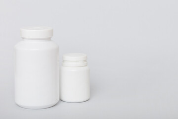 supplement pills with medicine bottle health care and medical top view. Vitamin tablets. Top view mockup bottle for pills and vitamins with green leaves, natural organic bio supplement, copy space