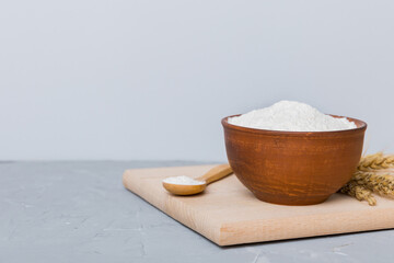Flat lay of Wheat flour in wooden bowl with wheat spikelets on colored background. world wheat...