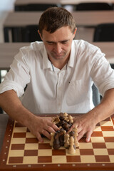 Middle aged Caucasian man playing chess. 