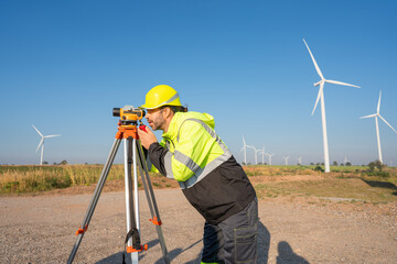 Engineer wearing uniform inspection and survey work in wind turbine farms rotation to generate electricity energy. Maintenance engineer working in wind turbine farm at sunset.