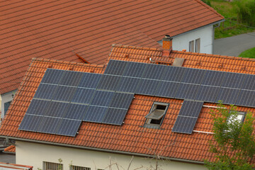A residential house featuring an extensive array of solar panels installed on its roof, promoting...