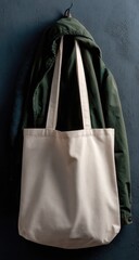 Cream tote bag hangs from hook, next to olive jacket