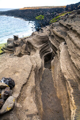 Scenic view of Green Sand Beach on Hawaii’s Big Island, featuring rare olive-green sand and...