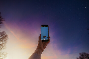 Hand holding phone taking picture of stars