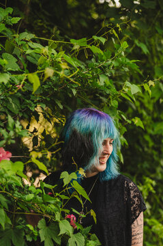 Transwoman with colorfully dyed hair in nature