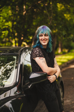 Young Transgender woman leaning on her car