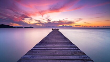A serene sunset view from a wooden dock extending into calm waters, with vibrant pink and purple hues in the sky.