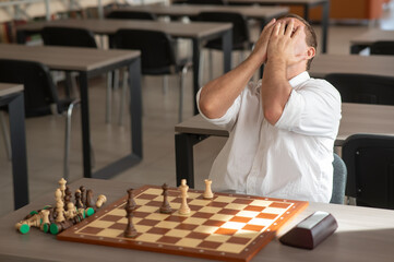 Middle aged Caucasian man playing chess. 