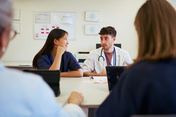 Medical team collaborating: doctor and nurses discussing patient care in hospital meeting