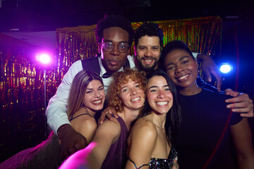 Friends taking selfie at nightclub party with disco lights