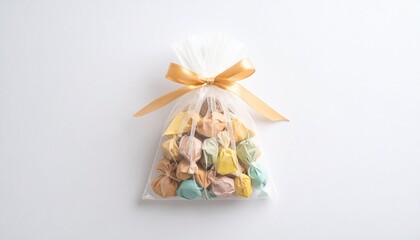 Chic transparent bag filled with assorted pastel candies, tied with a glossy gold bow &ndash; perfect for festive favors or elegant gift