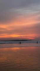 Stunning Sunset on a Tropical Beach with Colorful Sky and Silhouettes of People