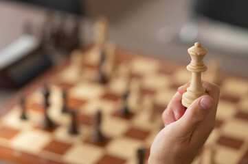 Close up of hands of middle aged caucasian man playing chess. 