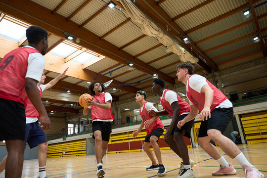 Basketball players defending during training in gym
