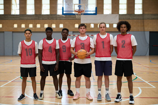 Basketball team posing on court before game - Powered by Adobe