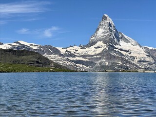 The Matterhorn mountain reflected in a blue alpine lake in Zermatt, Switzerland; Stellisee, 5 lakes walk