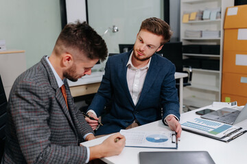 Diverse professionals collaborate on project analysis with financial graphs. Strategic teamwork and insights drive company growth and success.
