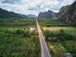 Aerial view of the asphalt road along the tropical forest in countryside