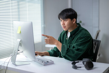 A man is pointing at something on a computer screen