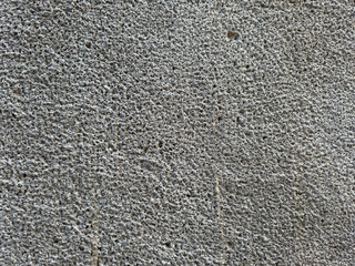 Porous cement wall with holes in it, wall background. There are some small holes in the wall