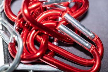 Detalle de varios mosquetones rojos metálicos, ideal para contenidos de escalada, deportes...
