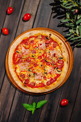 Delicious pizza topped with pepperoni, ham, and mushrooms on a wooden table