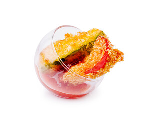 Crispy breaded vegetables served in a glass with tangy red dipping sauce, a colorful and elegant appetizer with a gourmet touch.