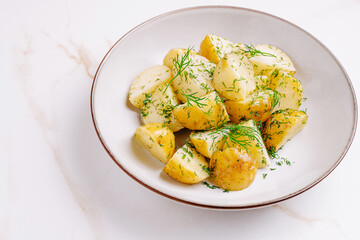 Freshly prepared boiled potatoes garnished with dill served in a bowl