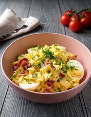 Potato sald with fresh herbs , scrambled eggs and bacon in a pale pink ceramic bowl on gray wooden table. Generated image