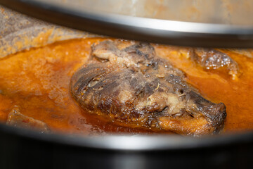 Carrillera de cerdo cocinada lentamente en salsa roja tradicional. / Pork cheek slowly braised in traditional red sauce.
