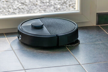 Robot vacuum cleaner with dust, real life photo, saves time and goes into hard-to-reach places