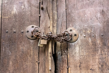 old wooden door with lock and a chain