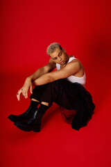 Young african american man showcases fashion in trendy red studio setting
