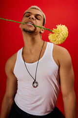 Daring style of a young man expressing confidence in a vibrant red studio setting