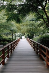 Fototapeta premium Tranquil wooden bridge in lush green park landscape