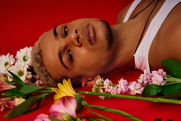 Unique fashion expression of a young African American man in vibrant red studio setting