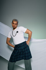 Confident young man displays bold fashion choices in studio setting