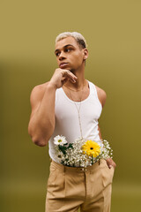 Young man showcases vibrant style with flowers in trendy studio setting