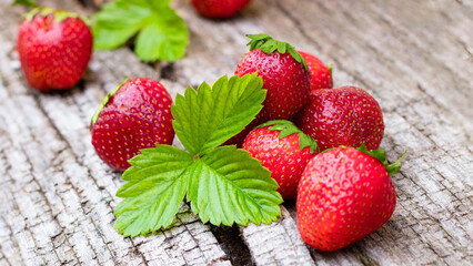 Juicy red strawberries on table with wooden texture