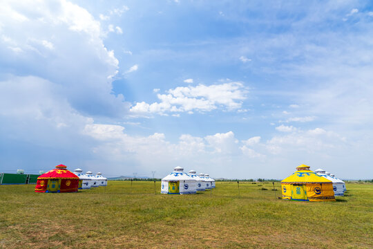 The yurt is under the blue sky and white clouds, yurts in the beautiful grassland