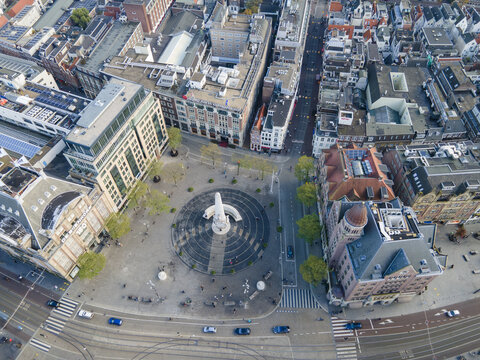 Aerial view of a bustling plaza where the Nieuwezijds Voorburgwal and the Damrak converge, surrounded by buildings, Amsterdam, North Holland, Netherlands.