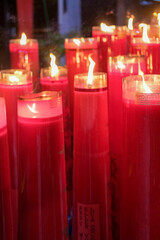 Giant red candles glow brightly in a temple during Chinese New Year and Cap Go Meh celebrations,...