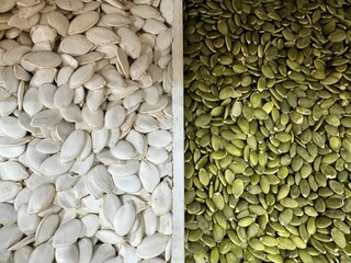 pumpkin seeds are shown in a peeled and unpeeled state with a dividing strip in the middle. white unpeeled pumpkin seeds on the left and green peeled pumpkin seeds on the right.