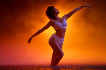 Fototapeta premium A woman dances expressively in skimpy white attire, illuminated by a striking orange background. Water surrounds her, suggesting an artistic and dynamic dance concept