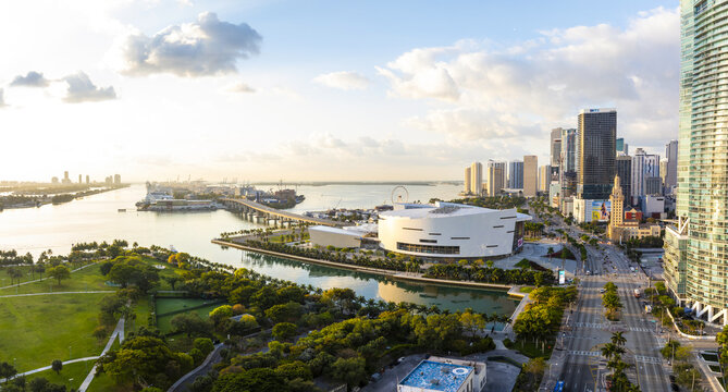 Aerial view of a vibrant cityscape where the white curves of the Frost Museum meet the glistening waters of Biscayne Bay, framed by the skyline, Miami, Florida, United States.