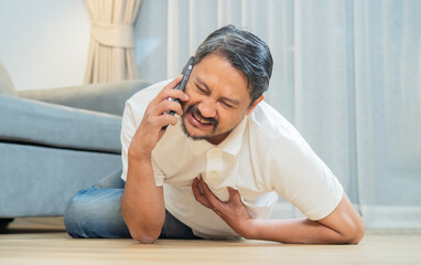Mature man fell down on floor and calling emergency services, suffering from chest pain.