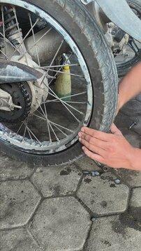 a motorcycle workshop technician is installing a tire that has just been repaired