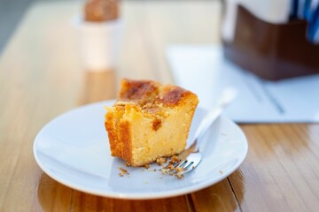 Cheesecake slice on a white plate with fork.