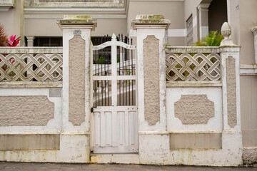 Vintage ornate gate and stone wall in a residential area.