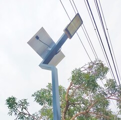 A low-angle shot of a modern street light featuring a solar panel on top, illustrating sustainable...